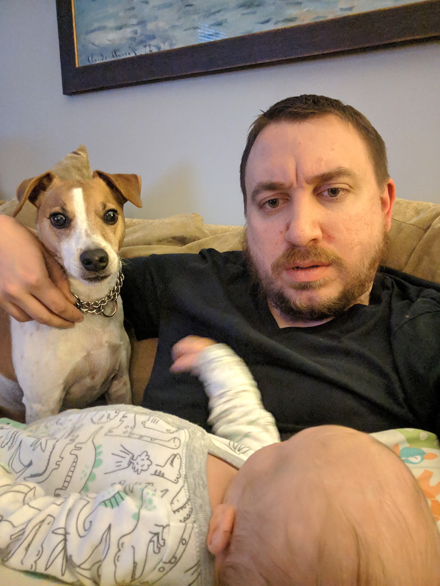 Eric on the couch with Seymour and a baby